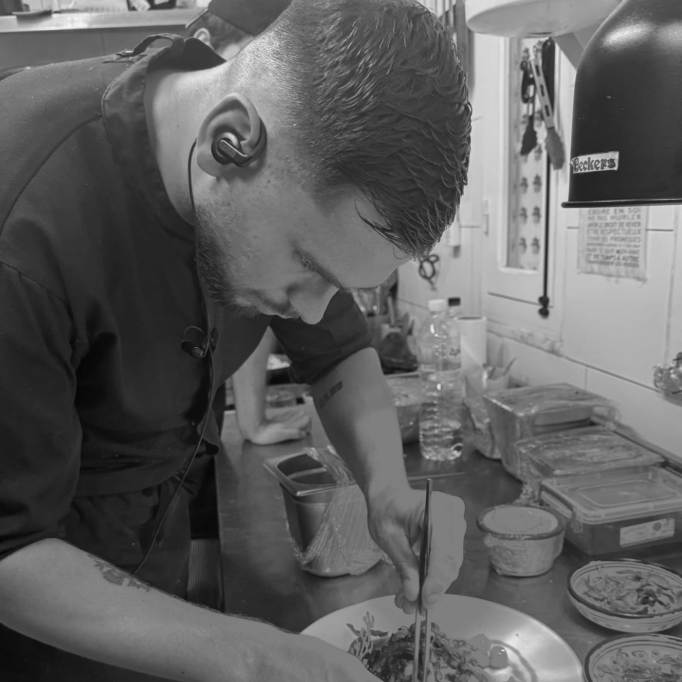 Le chef Grégoire dressant une assiette, soucieux du détail